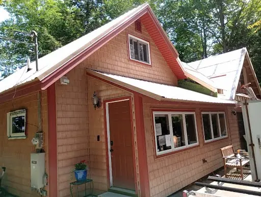 Completed maroon cedar addition with windows entry door and white trim