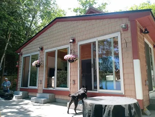 Completed maroon cedar exterior with large patio doors and trim
