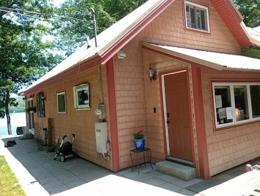 Completed maroon cedar-sided addition viewed from the side walkway