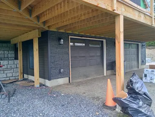Dark siding and trim installation beneath an elevated deck