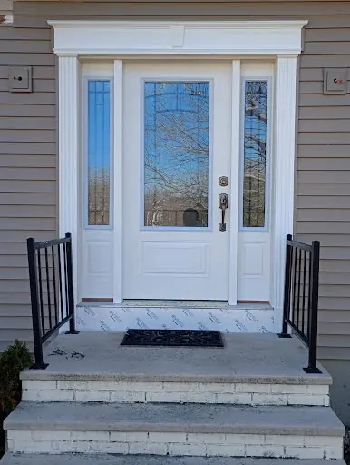 Completed white front entry surround with custom exterior trim and sidelights