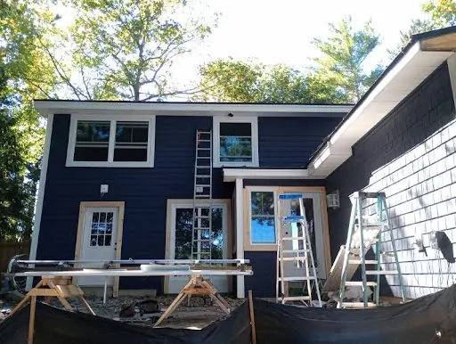 Dark siding being installed around windows and doors on a home addition