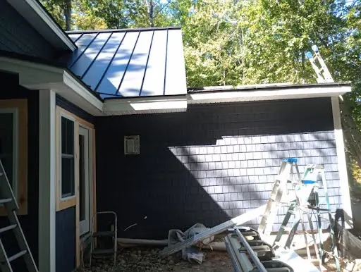 Dark shingle siding installation along the side of a home