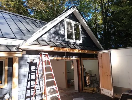 Exterior trim installation in progress above a garage