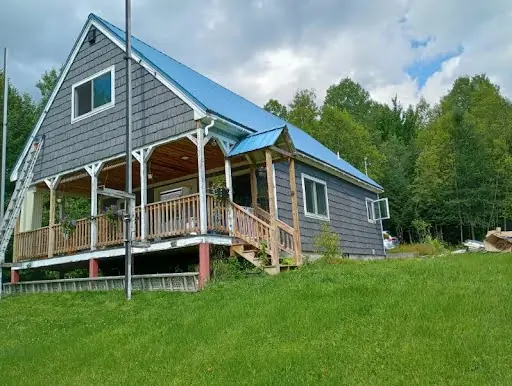Full view of the home after its blue-gray shingle siding transformation