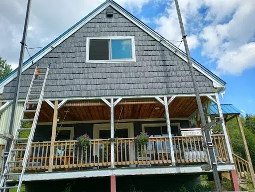 Covered porch after blue-gray shingle siding and white trim installation