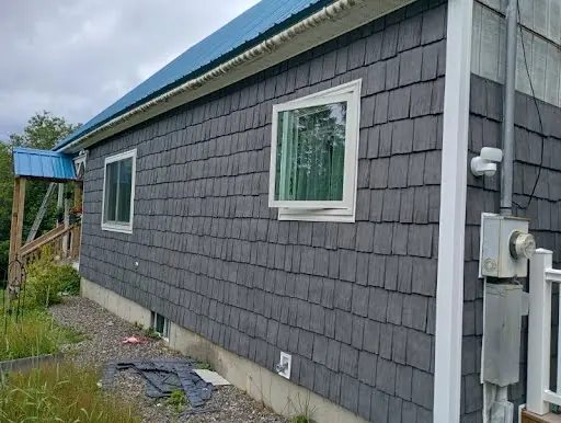 Window utility and corner details after blue-gray shingle siding installation