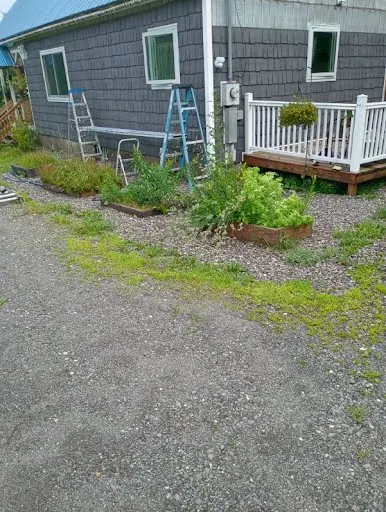 Blue-gray shingle siding installation in progress beside a white deck